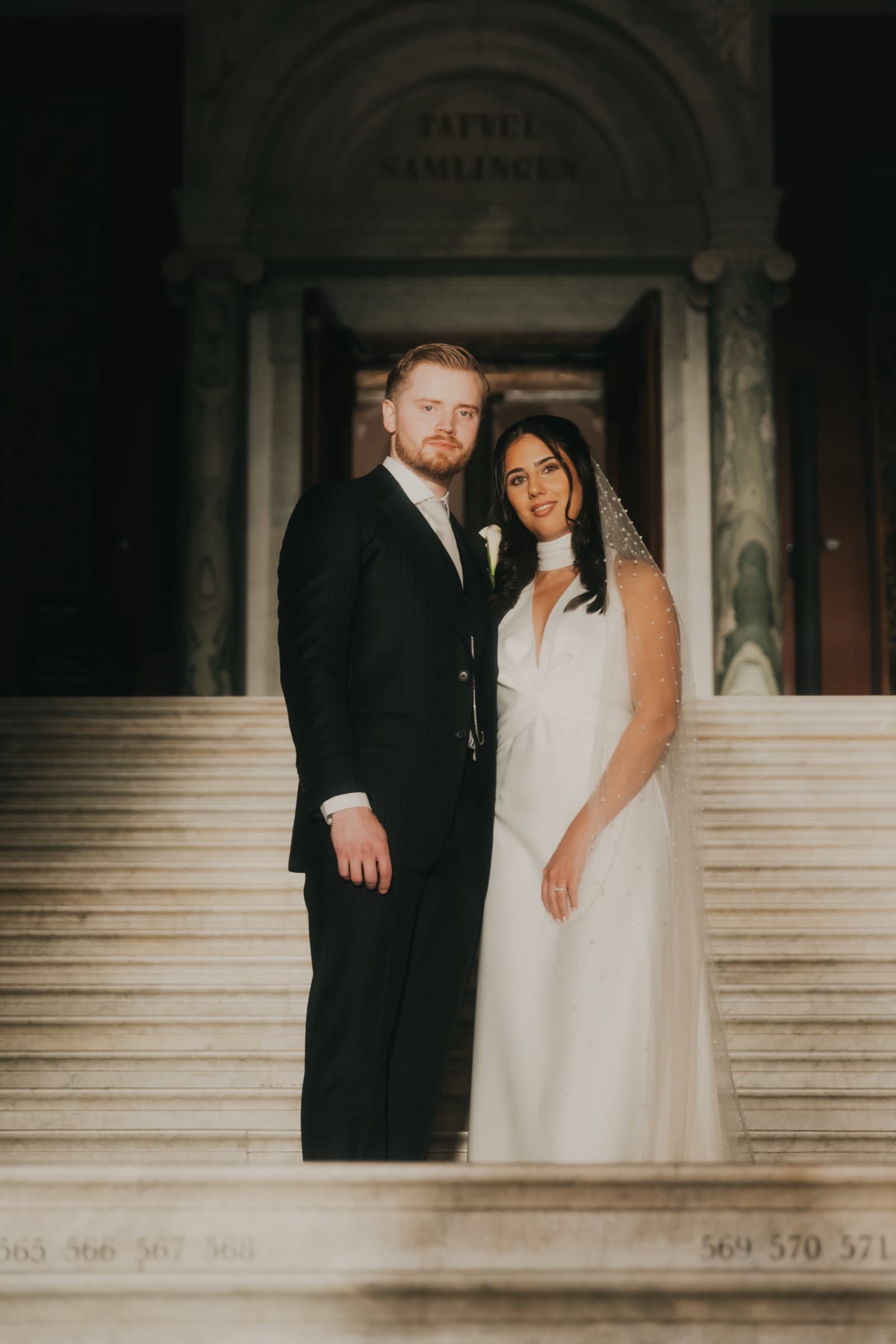 Couple on the museum steps beneath a carved inscription