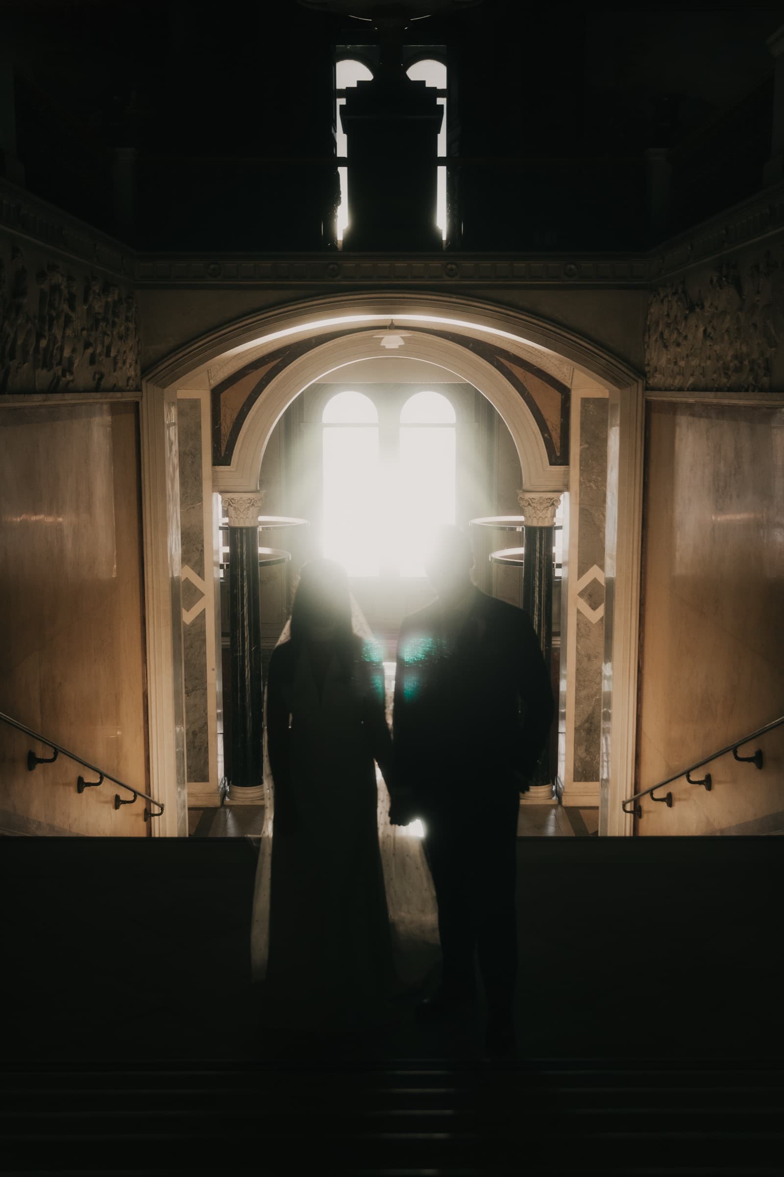 Couple silhouetted against a bright archway